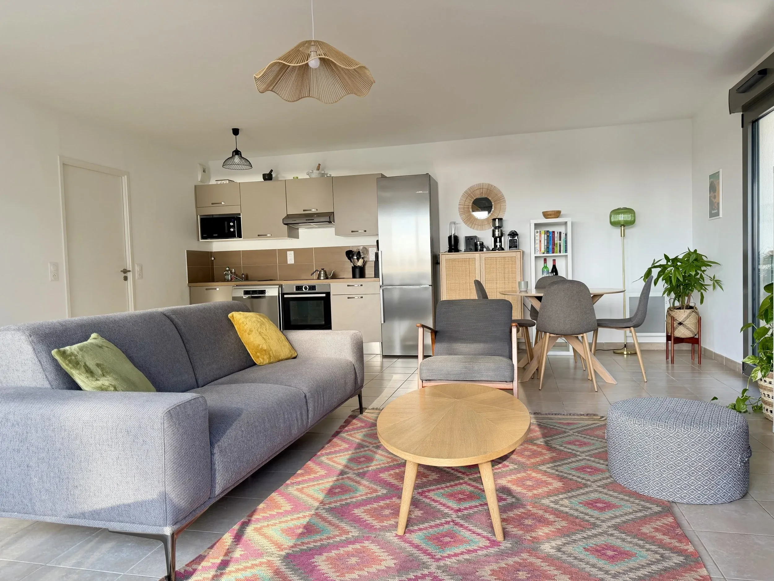 Salon et cuisine de l’appartement dans une palette de gris et de bois